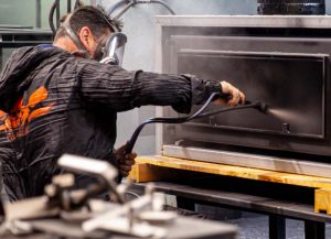 worker in a factory spraying a fireplace